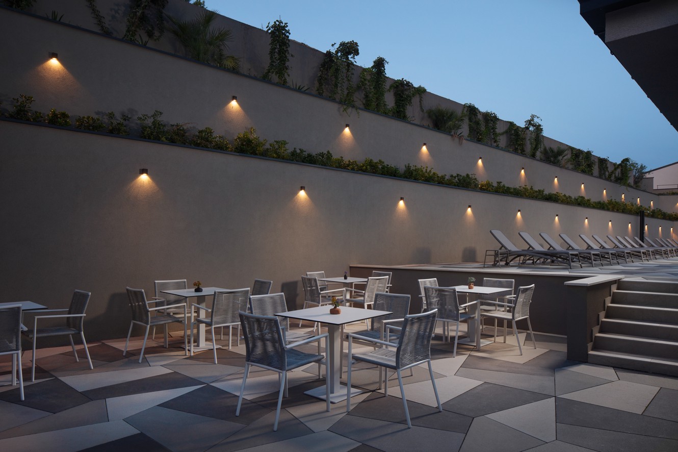 Buitenterras van de poolbar in het Aminess Alfir Resort met modern meubilair, sfeerverlichting en een ontspannen avondgevoel bij het zwembad