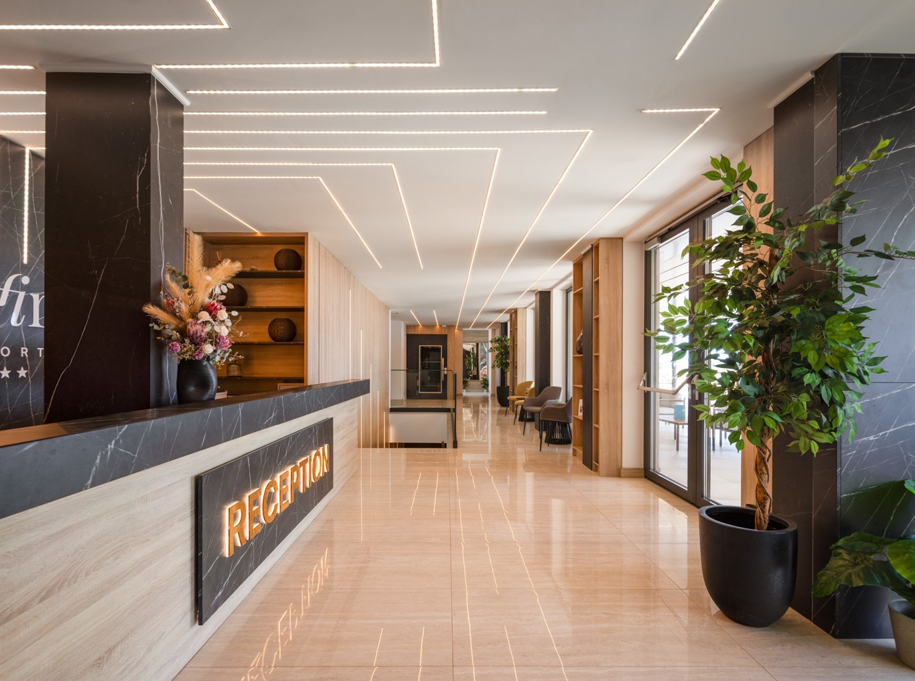 Receptie van Aminess Alfir Hotel met modern interieur en warme verlichting.