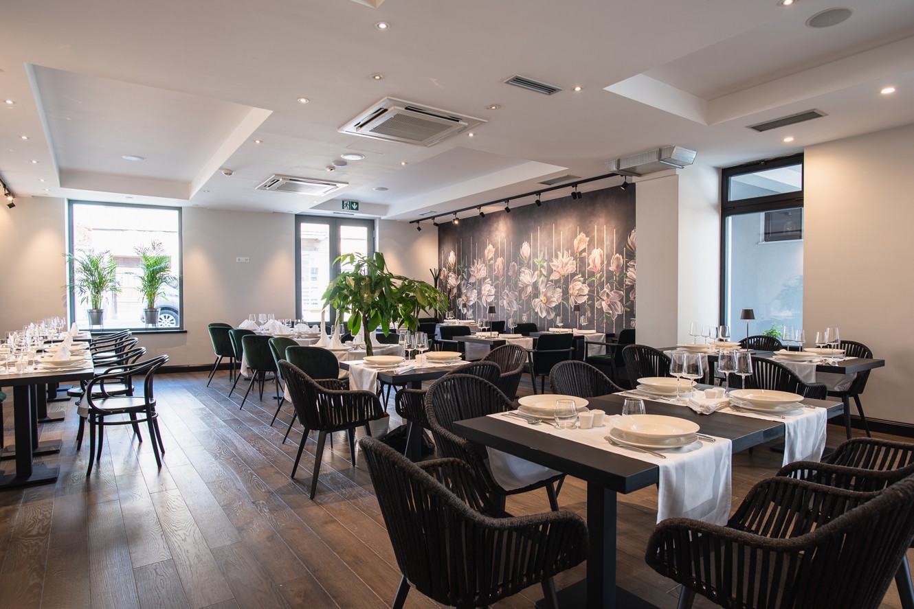 Hotel restaurant interior with floral wall and arranged dining tables