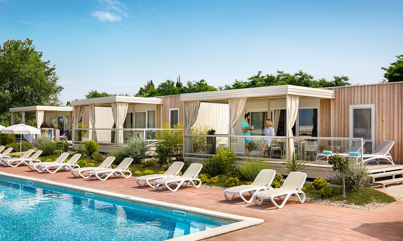 Paar auf der Terrasse eines Holiday Home mit Blick auf den Swimmingpool im Aminess Planet Camping Maravea Resort, Novigrad Kroatien