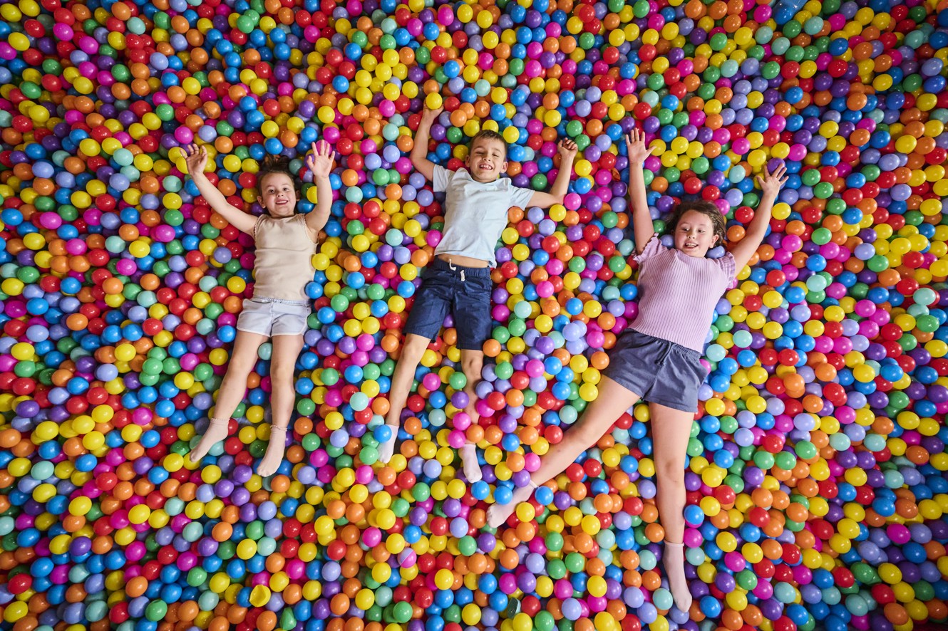 Bambini giocano e si sdraiano in una piscina di palline colorate nell area giochi