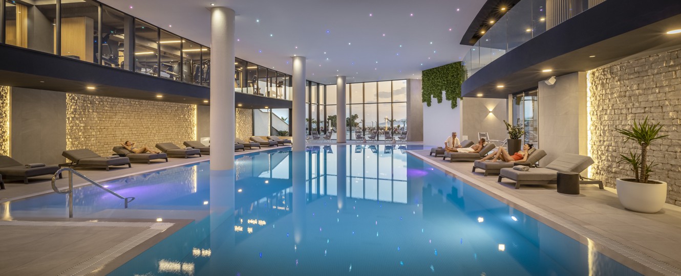 Paar entspannt am Schwimmbad im Aminess Laurel Khalani Hotel.