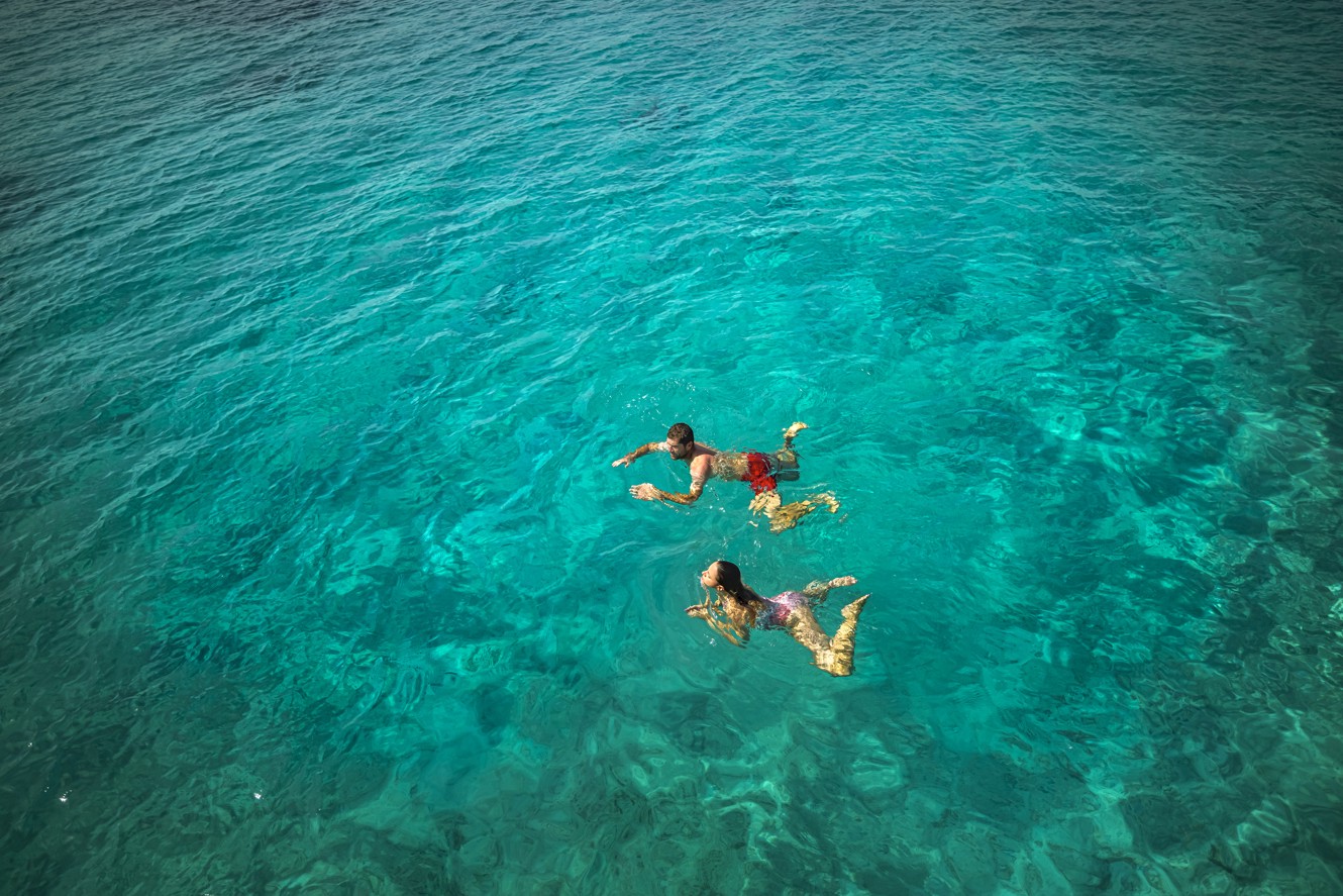 Zwei Schwimmer im kristallklaren Wasser in der Nähe von Aminess Port9 Planet Camping Korcula, genießen eine erfrischende Wasseraktivität in einer ruhigen Umgebung
