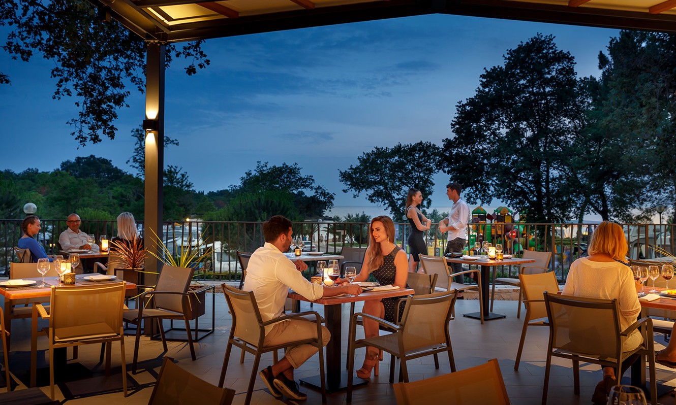 Couple enjoying a meal in a restaurant at Aminess Planet Camping Maravea Resort, Novigrad Croatia
