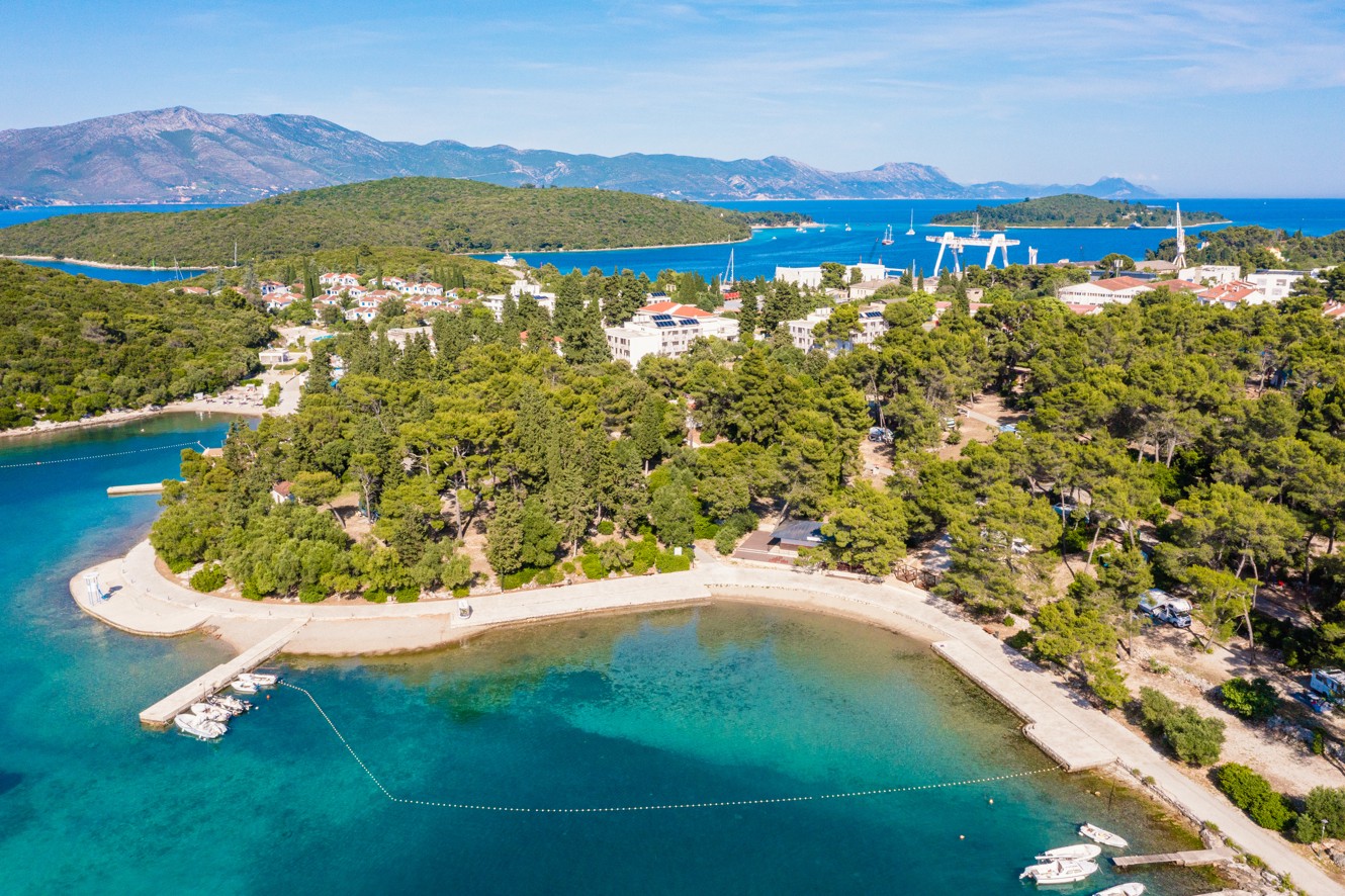 Panorama del resort Aminess Port9 Planet Camping, circondato dalla spiaggia e immerso negli alberi.