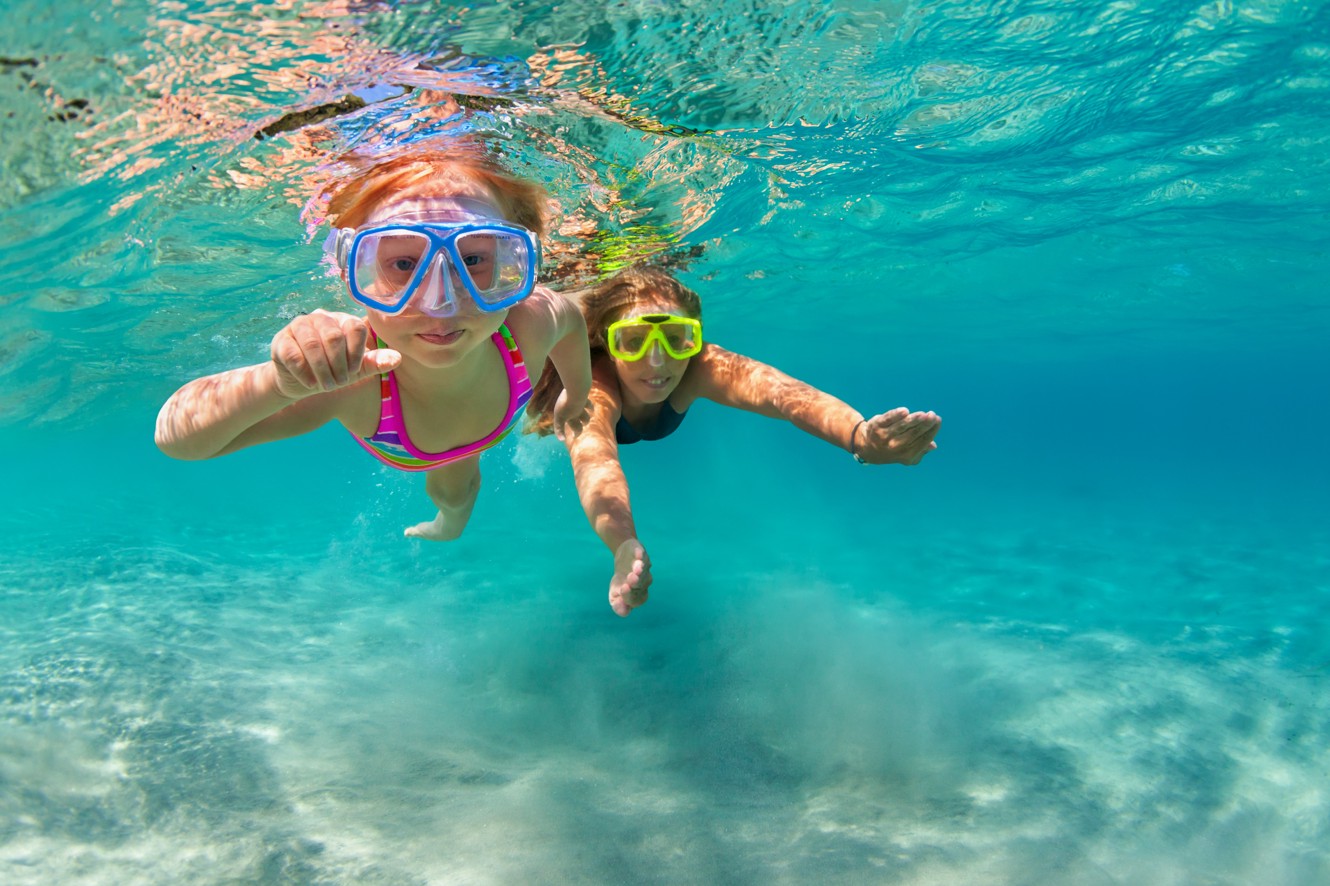 Due bambini che fanno snorkeling in acqua blu cristallina vicino a Port9 Planet Camping by Aminess, Korcula, con vita marina visibile.