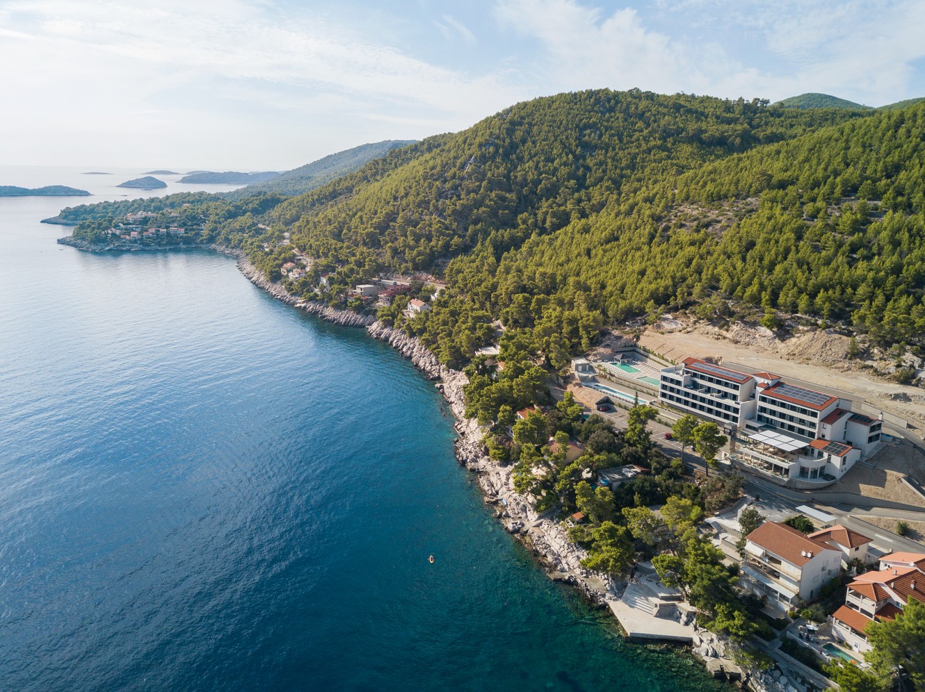 Luchtfoto van de kustlijn en natuurlijke omgeving rond Aminess Alfir Resort aan de kristalheldere zee