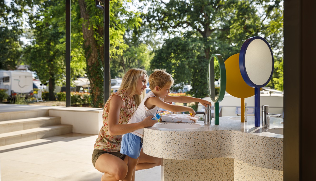 Mother and son washing hands at the sanitary facilitie at Aminess Planet Camping Maravea, Novigrad