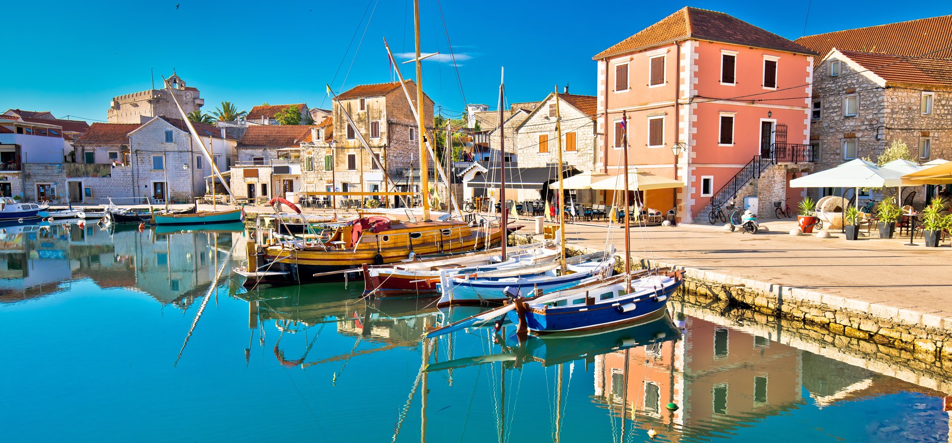 Slikovit pogled na Vrbosko na otoku Hvaru, Hrvaška, ki prikazuje očarljive kamnite hiše, čolne v kanalu in bujno sredozemsko pokrajino - Aminess destinacija potovanja.