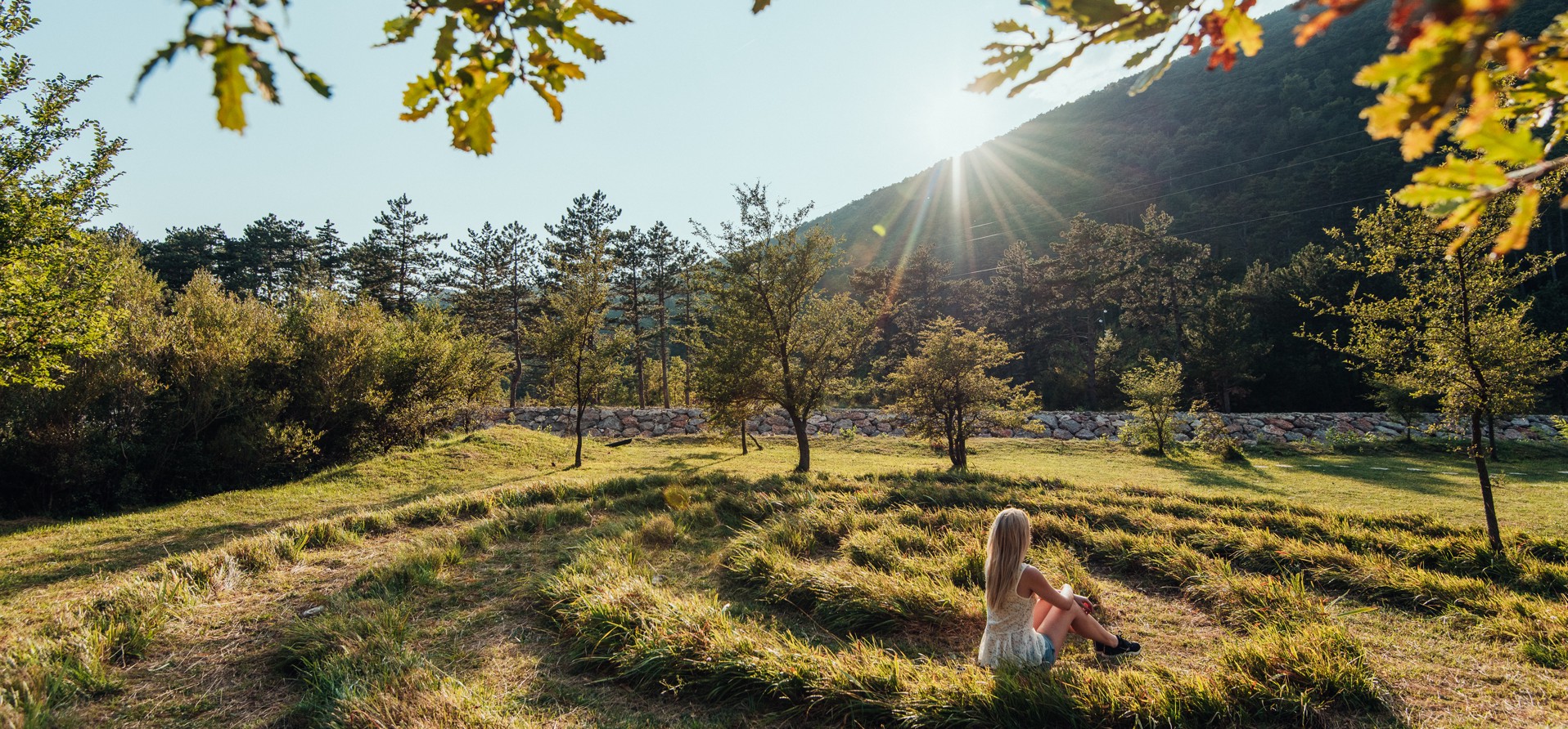 Mediteranski Labirint ljubavi blizu Crikvenice, s mirnim prirodnim okruženjem i sunčevom svjetlošću koja se probija kroz drveće.