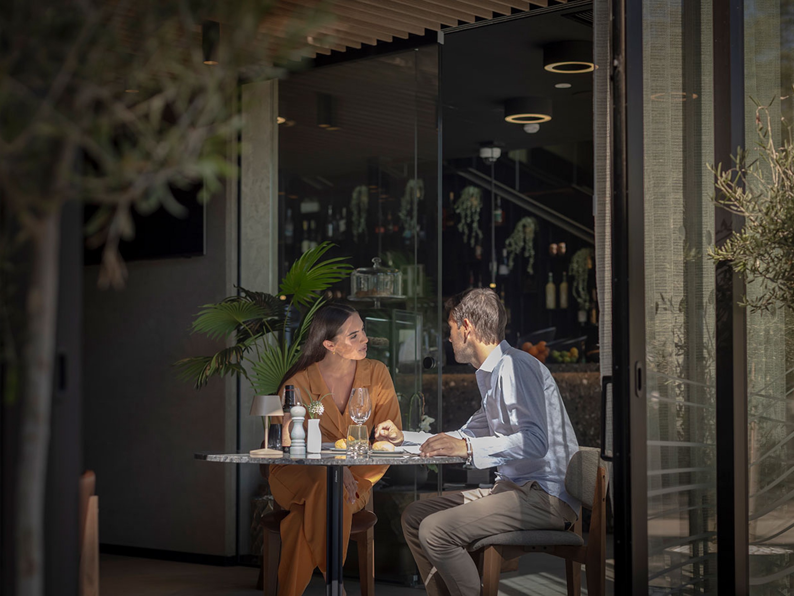 Gosti uživaju u večeri u modernom i profinjenom restoranu.