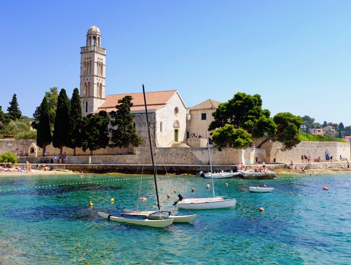Historisch klooster op het eiland Hvar, Kroatië, omgeven door weelderig mediterraan groen en met uitzicht op de serene Adriatische Zee - Aminess bestemming reizen.