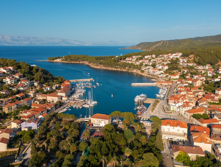 Bezaubernder Blick auf die Stadt Jelsa auf der Insel Hvar, Kroatien, mit einem malerischen Hafen, traditionellen Steinhäusern und mediterraner Vegetation - Aminess Reiseziel.
