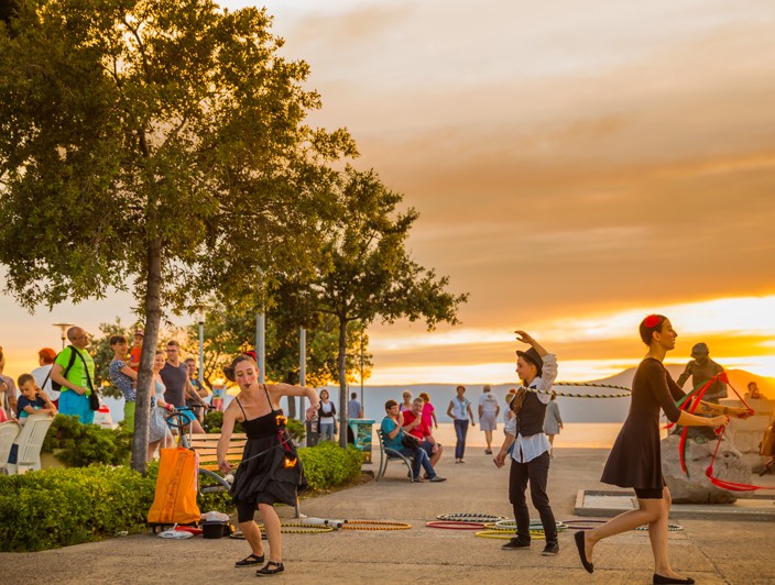 Street performers entertaining visitors during sunset on Krk Island, Croatia.