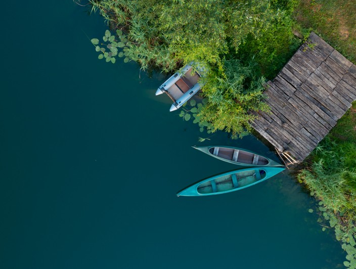 Vista aerea delle barche lungo la riva del fiume Mreznica e molo in legno nella natura