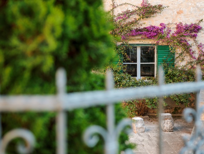 Architettura tradizionale sull'isola di Brač, Croazia, con edifici in pietra dal fascino rustico, strade strette e vegetazione mediterranea.