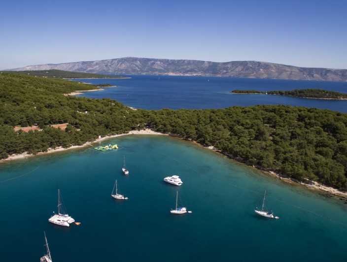 Idilična plaža na otoku Hvaru, Hrvatska, s kristalno čistim vodama Jadrana, stjenovitim obalama i bujnim mediteranskim krajolikom - Aminess destinacija za putovanje.