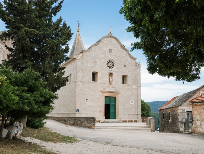 Traditionelles Steindorf auf der Insel Brač, Kroatien, das das lokale Erbe mit rustikalen Steinhäusern, engen Straßen und mediterraner Vegetation präsentiert.