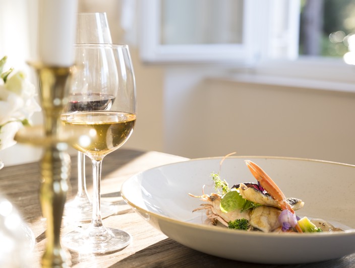 Elegant dining setup with beautifully plated dishes and fine wine in Orebic, Peljesac Peninsula.