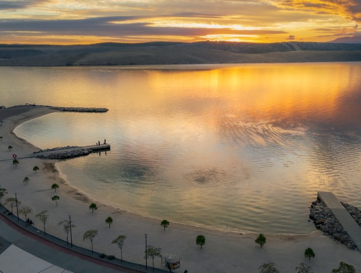 Beach in Jadranovo near Crikvenica, captured at sunset with calm sea and a serene atmosphere.