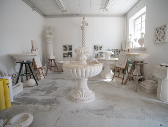 Una stanza con piccoli pilastri in pietra e una fontana centrale in pietra sull'isola di Brac, Croazia, che mette in mostra l'artigianato tradizionale in pietra e il design architettonico.