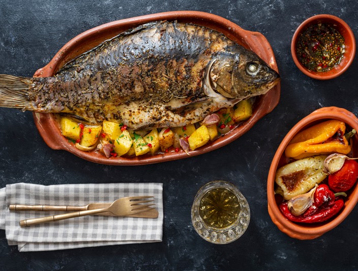 Pecen krap s krompirjem kot tradicionalna jed lokalne kuhinje