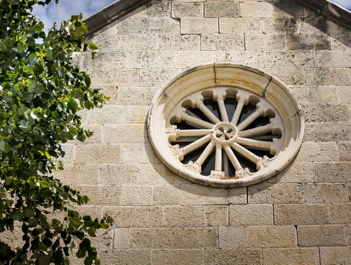 Close-up of a detailed stone window, showcasing the rich architectural heritage of Korcula Island.