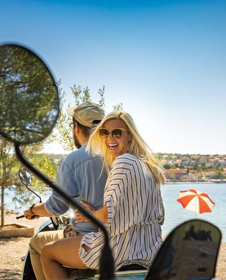 Coppia in scooter sul lungomare a Njivice, si gode una vacanza soleggiata con Aminess