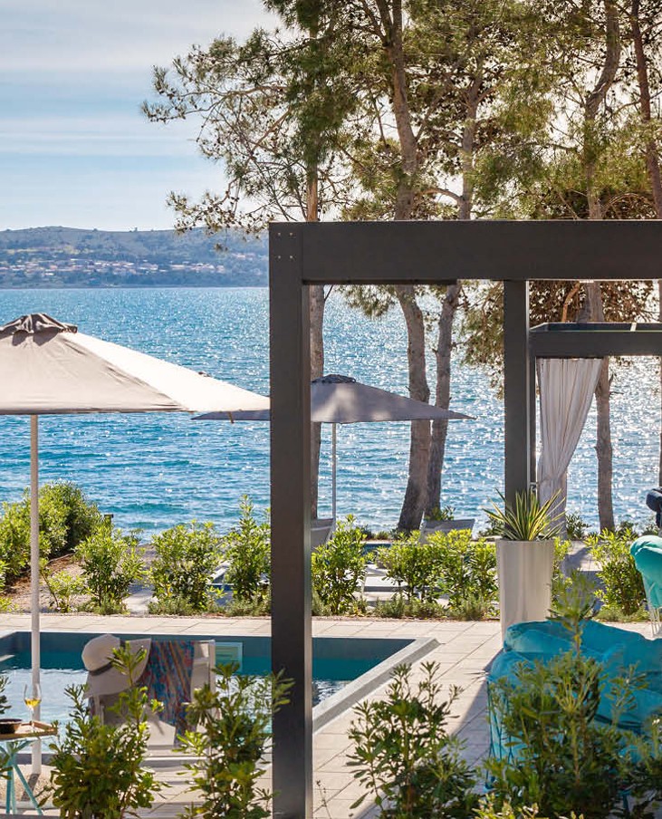View of the Holiday Home house with pool and open parasol by the sea at Aminess Style Camping Avalona resort.