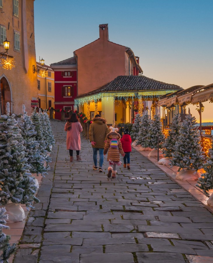 Kamnita ulica v Motovunu okrašena z božičnimi lučkami
