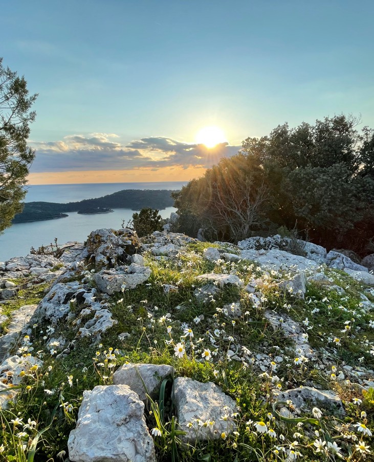 Zalazak sunca nad morem i stjenovitim krajolikom u blizini Aminess destinacije.