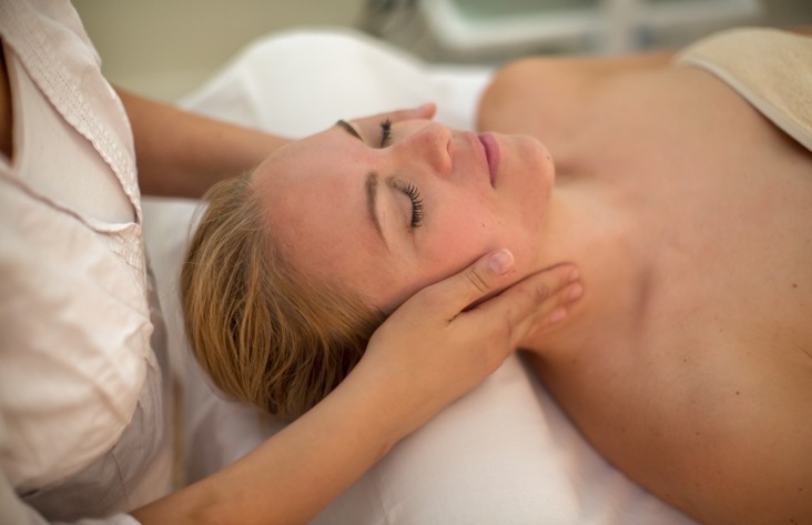 Osoba cieszy się relaksującym zabiegiem spa na twarz w spokojnym wellnessowym otoczeniu