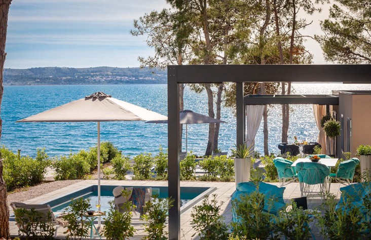 View of the Holiday Home house with pool and open parasol by the sea at Aminess Style Camping Avalona resort.