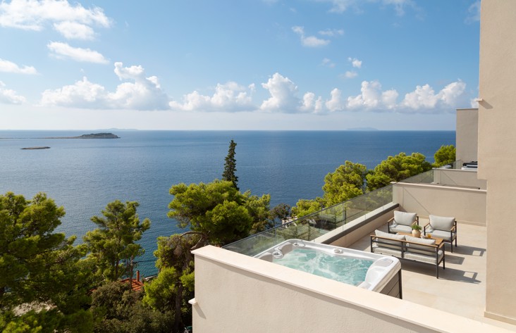 Terrazza all’Aminess Alfir Resort con jacuzzi privata e vista aperta sul mare, circondata dal verde mediterraneo