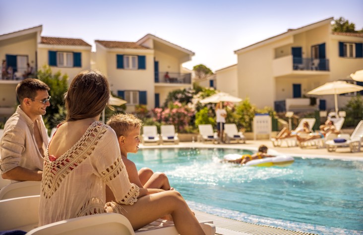 Family relaxing by the the pool within resort near Aminess Port9 Residence.