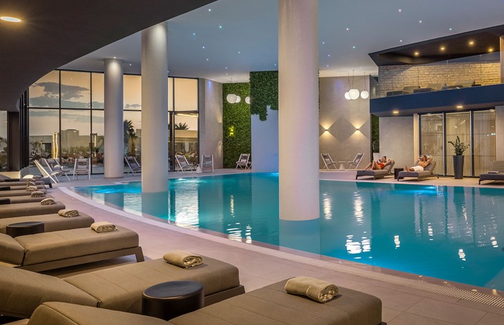 Kryty basen spa Aminess Khalani z leżakami i spokojnym oświetleniem.