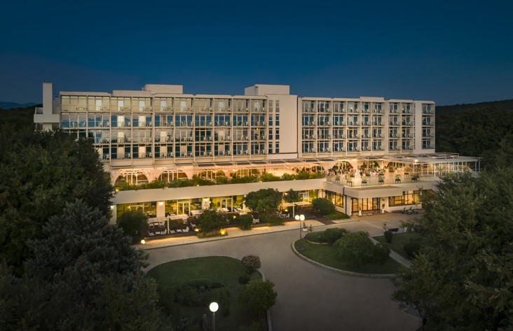 Nachtansicht des Magal Maradiso Hotels von Aminess mit Lichtern und Bäumen.