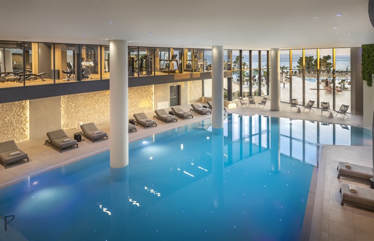 Moderan unutarnji bazen s pogledom na teretanu i ležaljke u hotelu Aminess Laurel Khalani.