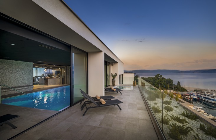Indoor pool with a sea view at sunset at Aminess Younique Narrivi Hotel.