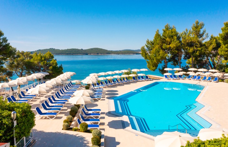Stunning seaside view of the pool area surrounded by natural beauty at Aminess Vival Grand Azur Hotel.