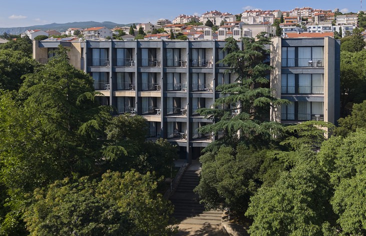 Vista dell’hotel Aminess Vival Casa Lišanj circondato dal verde, con il panorama di Novi Vinodolski sullo sfondo.