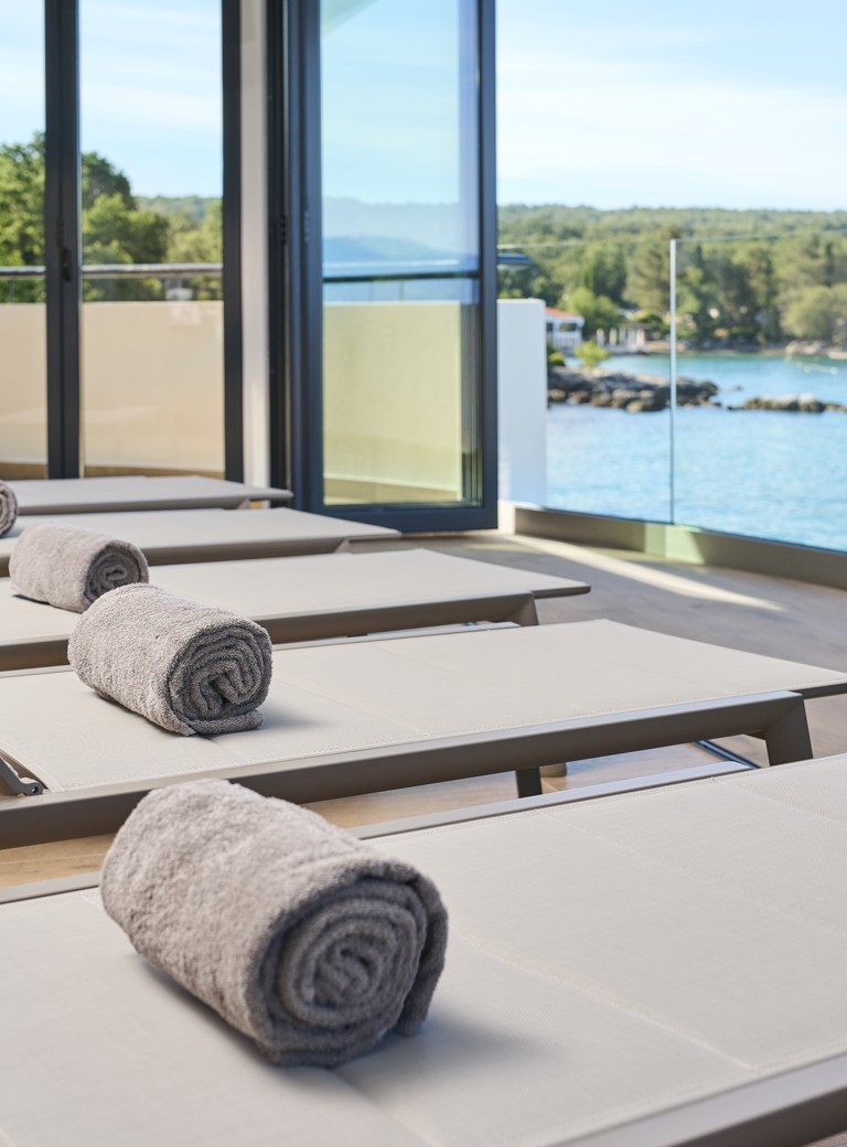 Comfortable spa lounge chairs with a view of the sea and serene surroundings at Aminess Style Camping Atea Resort.