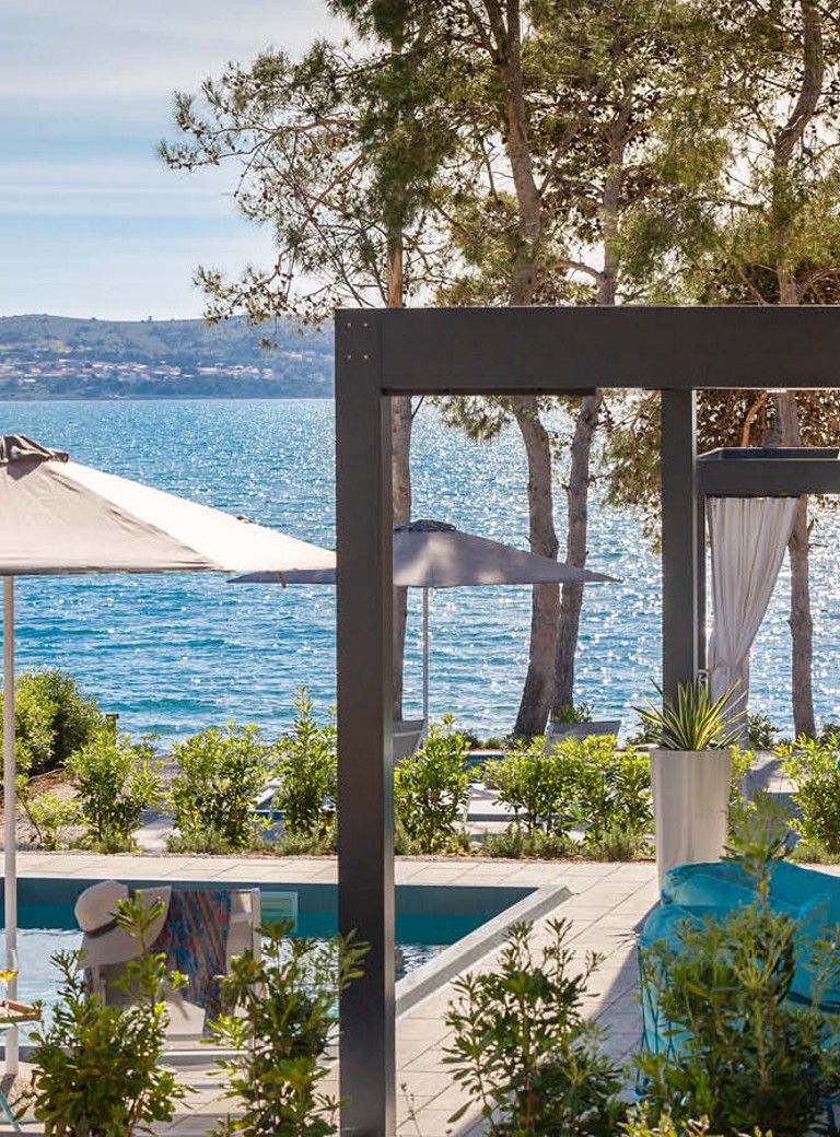 View of the Holiday Home house with pool and open parasol by the sea at Aminess Style Camping Avalona resort.