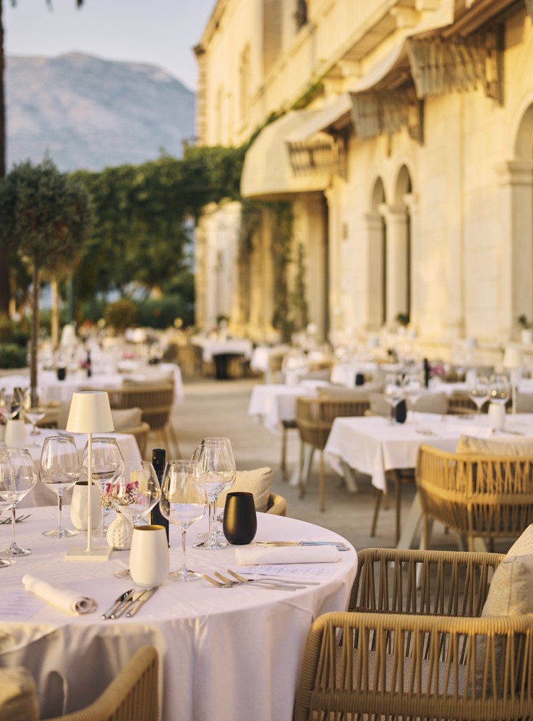 Elegantno i luksuzno uređena terasa stola u restoranu i baru 7 Seas unutar povijesnog Aminess Korcula Heritage Hotela tijekom zlatnog sata