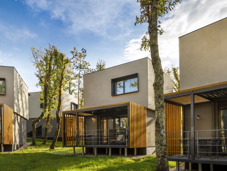 Pogled izvana na Aminess Younique Gaia Green Villas okružene drvećem, ističući modernu arhitekturu i prirodnu integraciju.