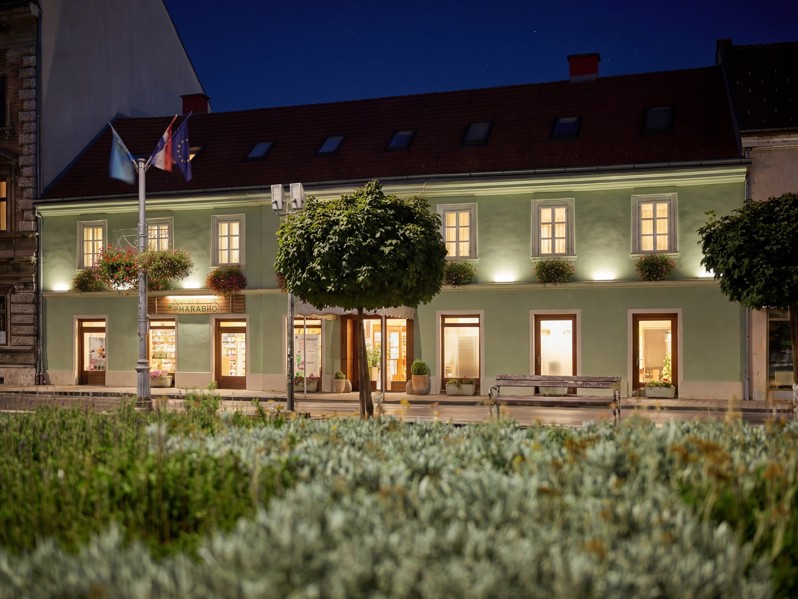 Aminess hotel in Karlovac s nachts met verlichte gevel en park ervoor
