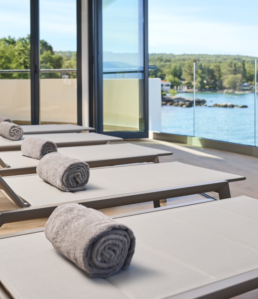 Comfortabele spa-lounge stoelen met uitzicht op de zee en serene omgeving bij Aminess Style Camping Atea Resort.