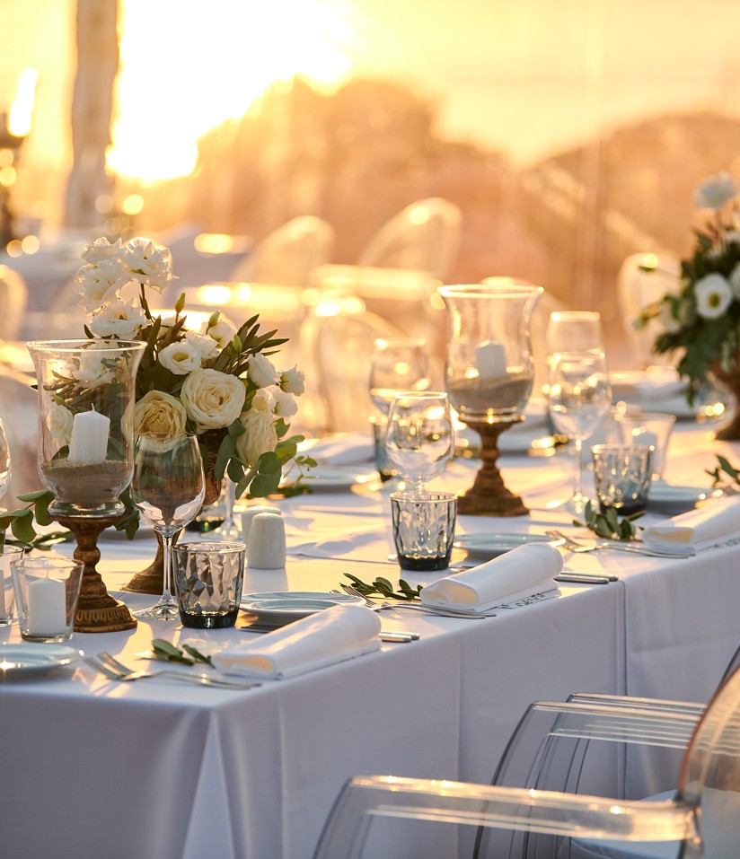 L'immagine mostra una decorazione da tavolo di matrimonio con fiori e segnaletica del numero di tavolo.