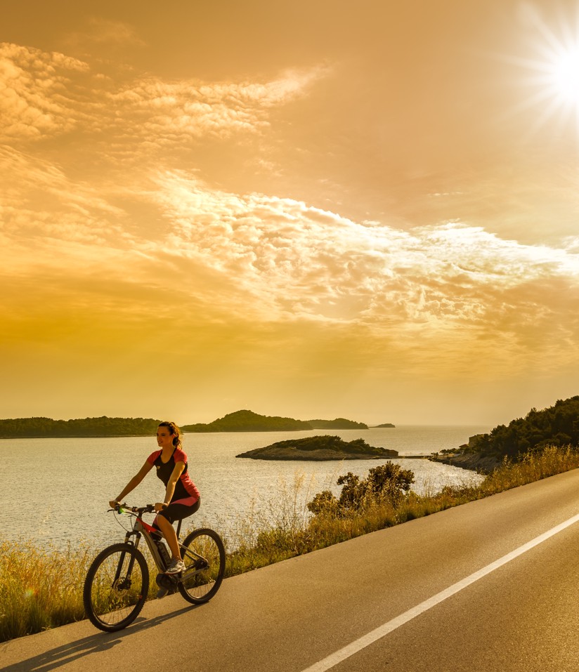 Een fietser die de prachtige kustwegen rond Port9 Planet Camping by Aminess verkent.