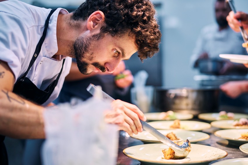 Chef carefully plates a dish at 7 Seas restaurant.